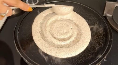 Crispy ghee karam onion egg dosa topped with onions and podi